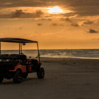 Golf cart parked on beach near sunset in Port Aransas, Texas